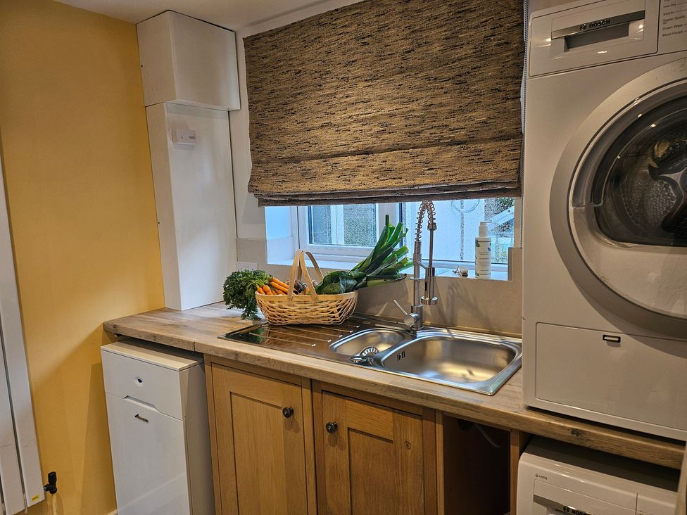 A kitchen with a sink and washing machine at Rockhurst Farm in Matlock