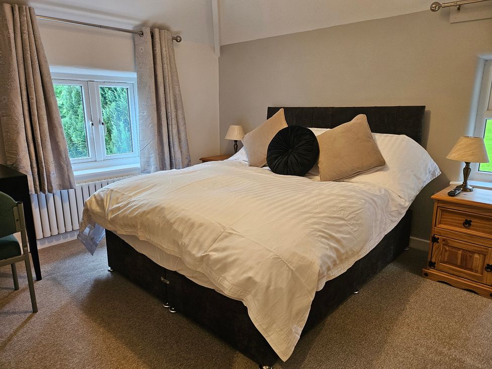A bedroom with a bed and lamps at Rockhurst Farm in Matlock