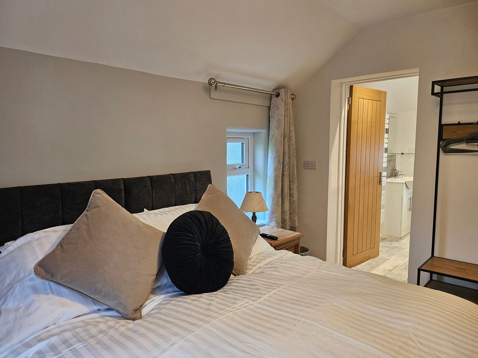 A bedroom with a bed and a door leading to a bathroom at Rockhurst Farm in Matlock