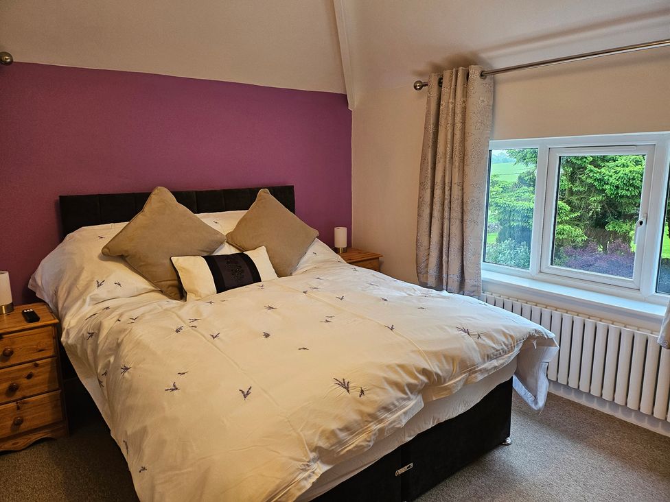 A bedroom with a bed and a window at Rockhurst Farm in Matlock