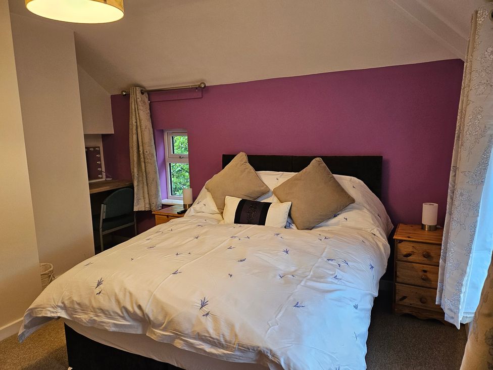 A bedroom with a bed and window at Rockhurst Farm in Matlock