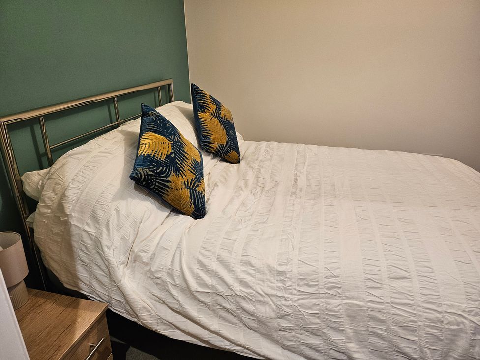 A bed with decorative pillows in a bedroom at Rockhurst Farm Matlock