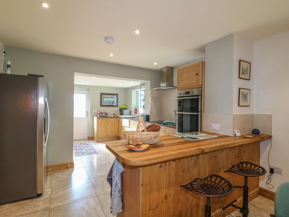 A kitchen with a countertop and bar stools at Rockhurst Farm near Winster