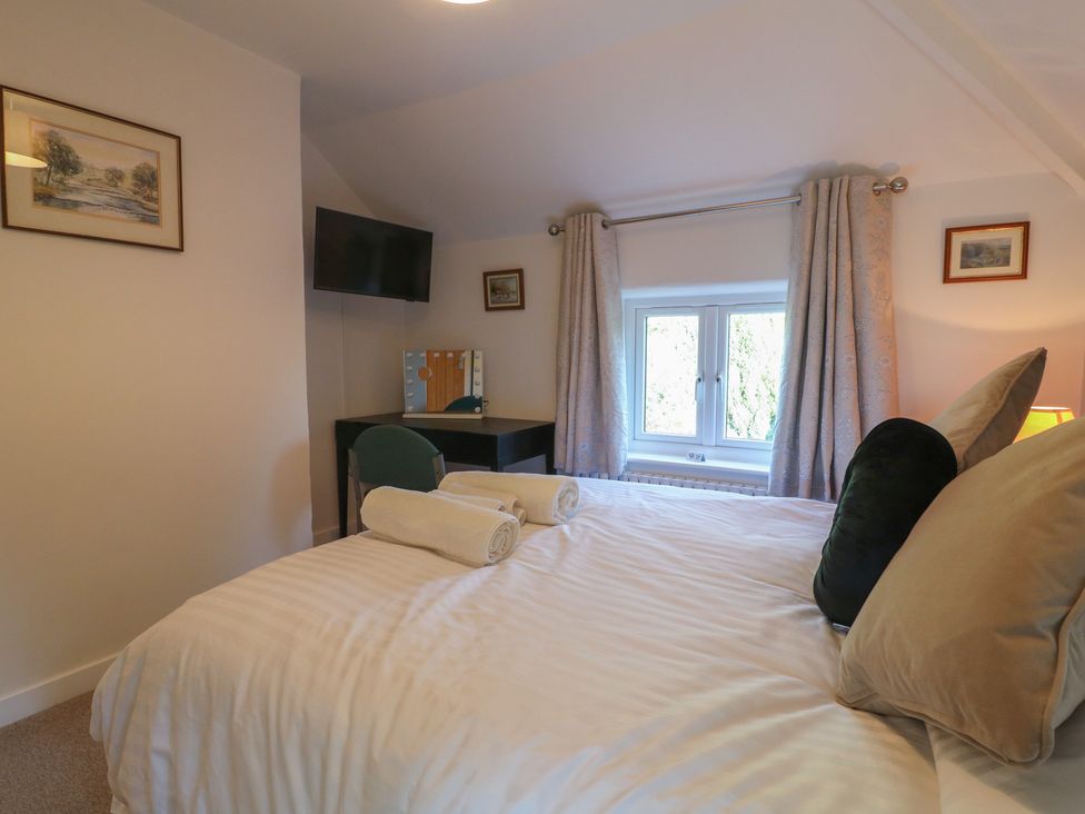 A bedroom with a bed, television, and desk at Rockhurst Farm near Winster