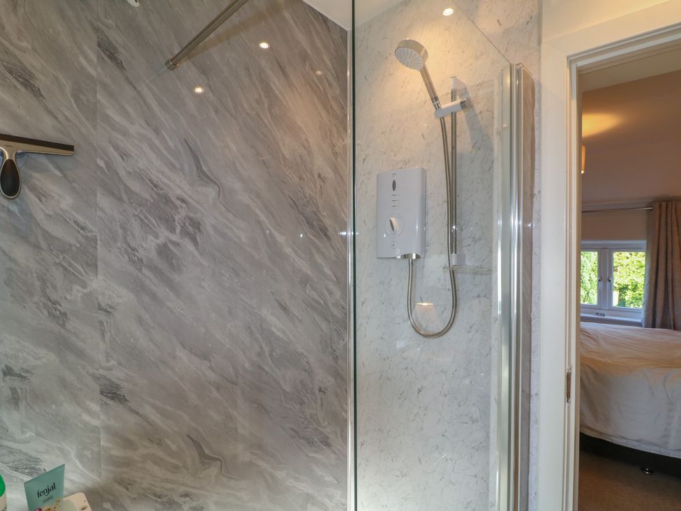 A shower with glass panel and marble wall at Rockhurst Farm near Winster