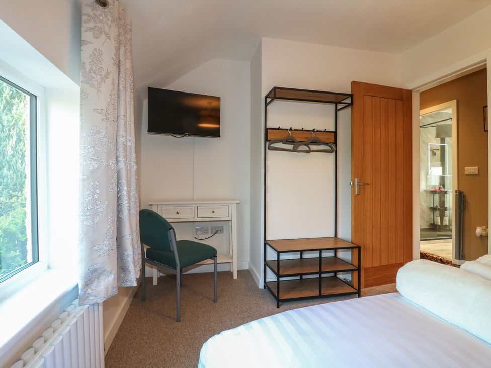 A bedroom with a television and a desk at Rockhurst Farm near Winster