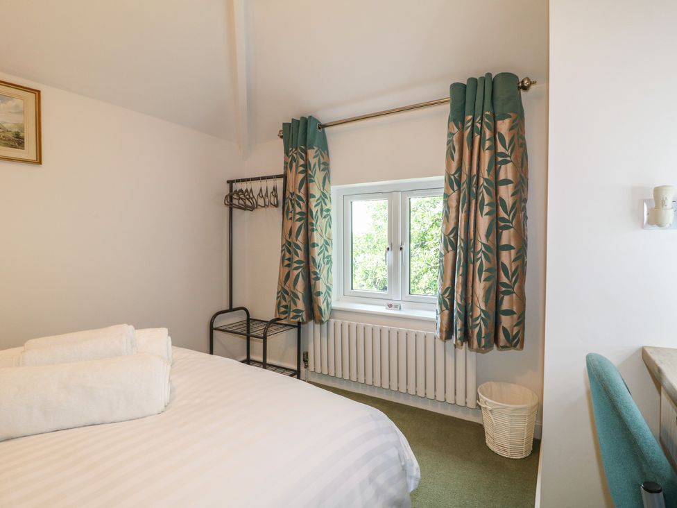 A bedroom with a bed and window at Rockhurst Farm near Winster