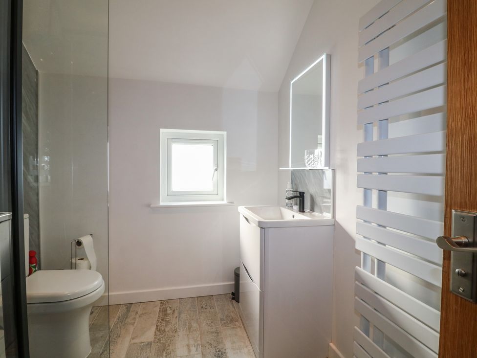 A bathroom with a sink, toilet, and window at Rockhurst Farm near Winster