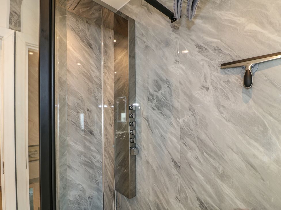 A shower enclosure with controls and marble walls at Rockhurst Farm near Winster