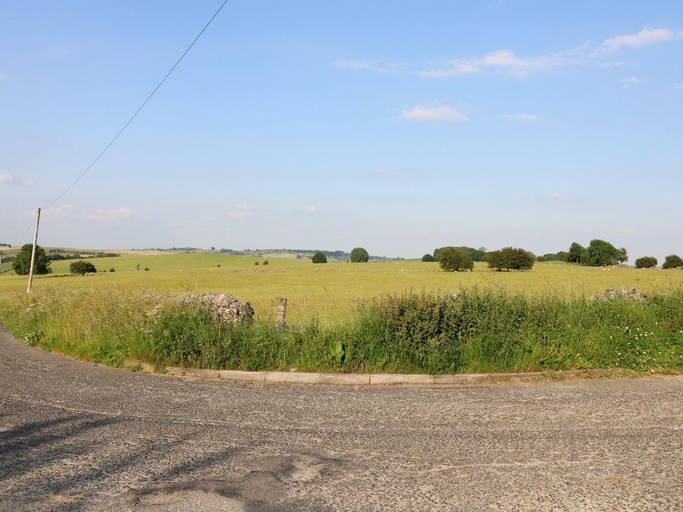A view of a field with trees and a road at Rockhurst Farm near Winster
