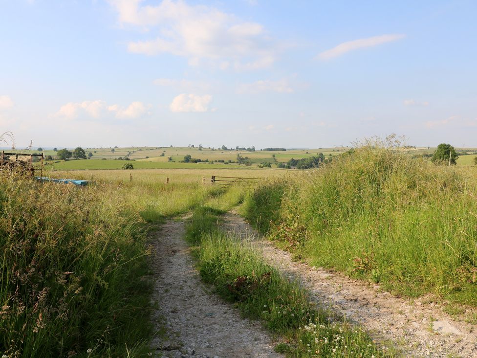 A dirt path leading through grass fields at Rockhurst Farm near Winster