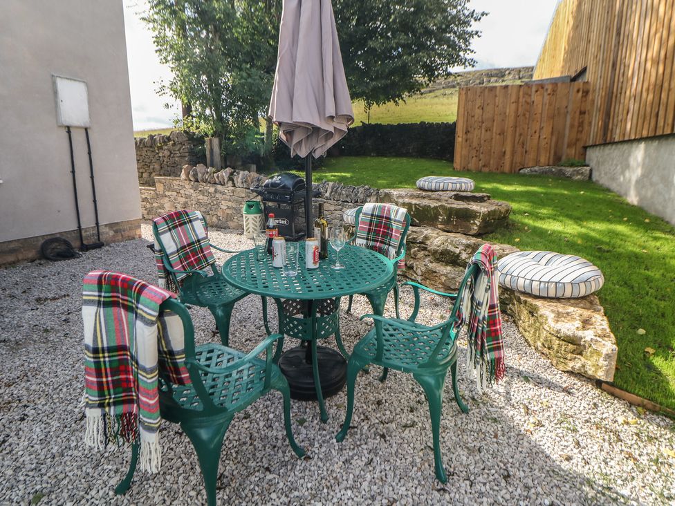A garden with a table and chairs at Rockhurst Farm near Winster