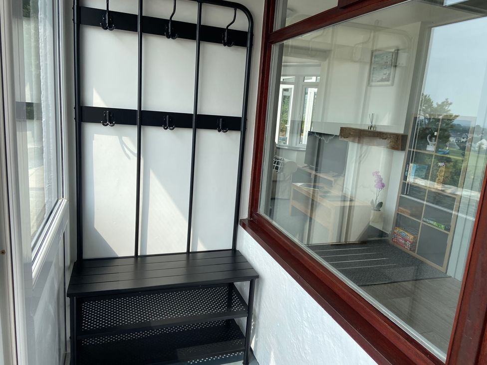 A hallway with a coat rack and bench at Hafod Y Graig in Morfa Bychan