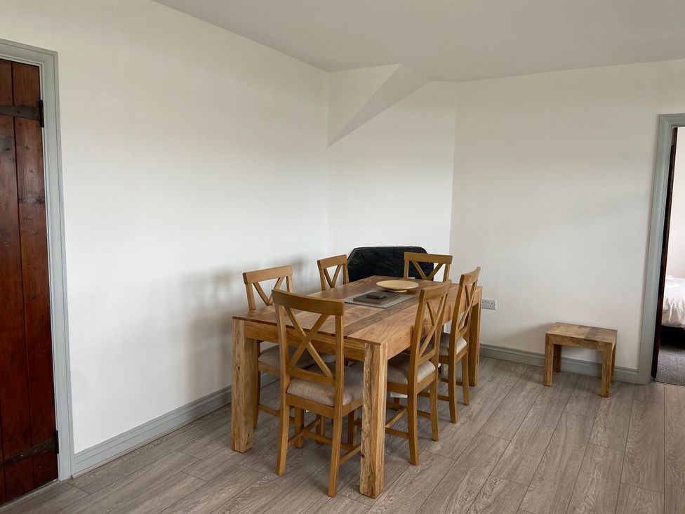 A dining room with a table and chairs at Hafod Y Graig in Morfa Bychan