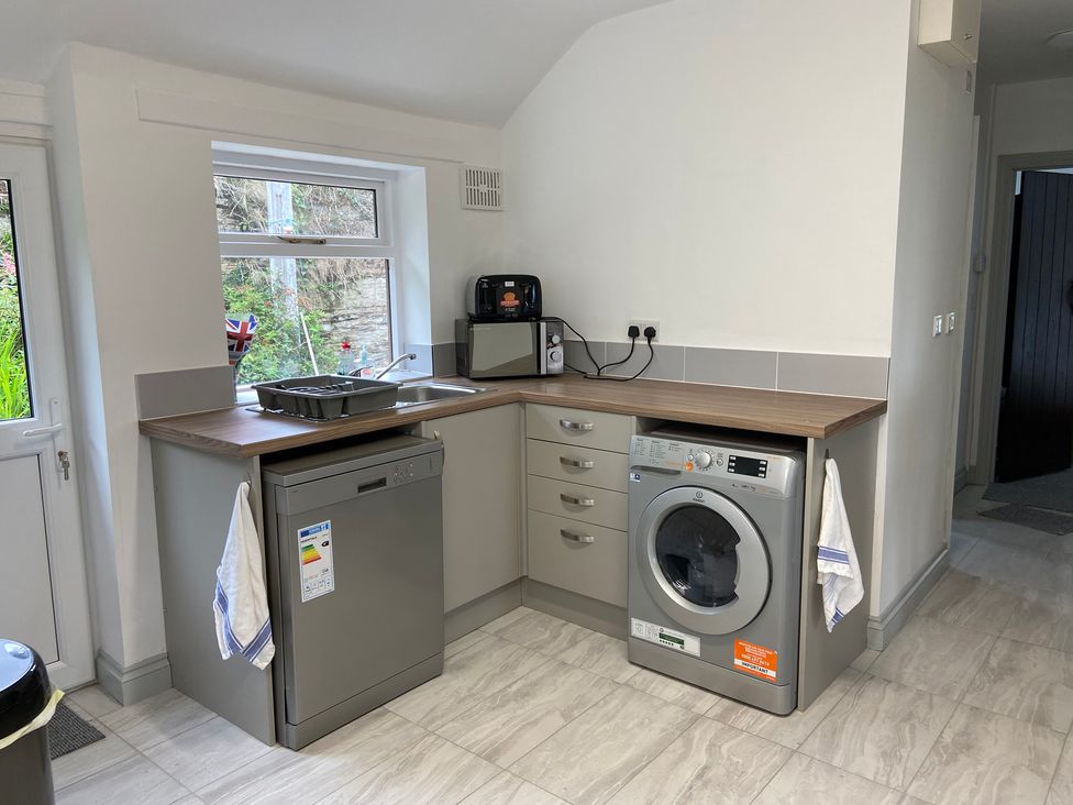 A kitchen with a washing machine and dishwasher at Hafod Y Graig in Morfa Bychan