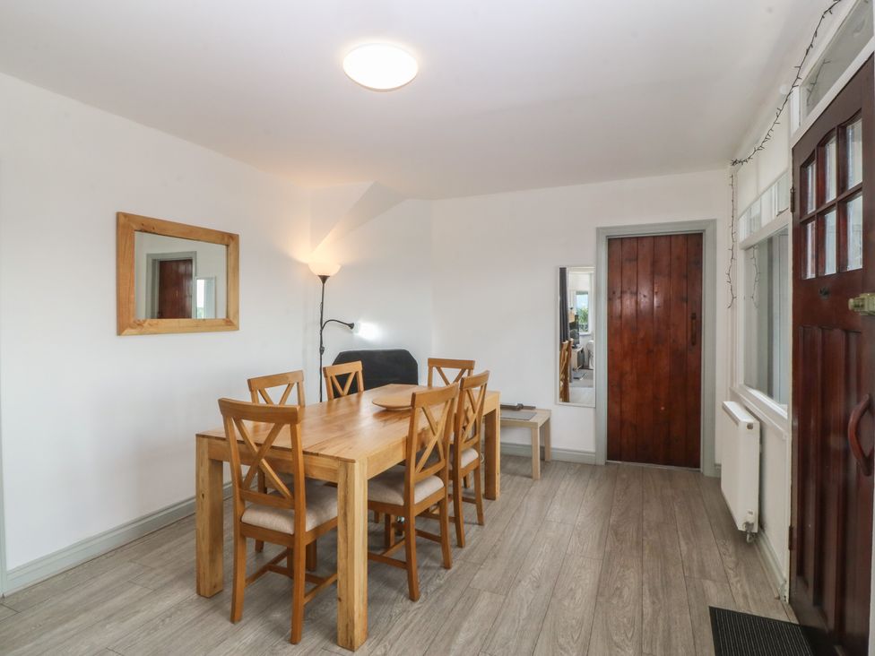 A dining room with a table and chairs at Seaview Hafod Y Graig in Morfa Bychan