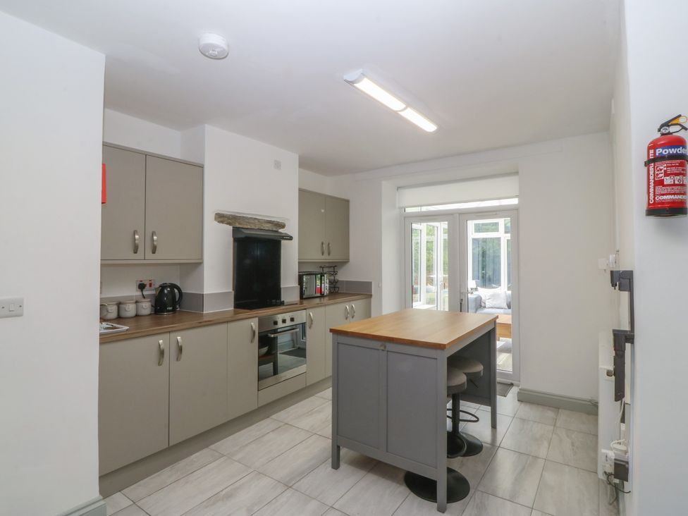 A kitchen with cabinets and appliances at Seaview Hafod Y Graig in Morfa Bychan