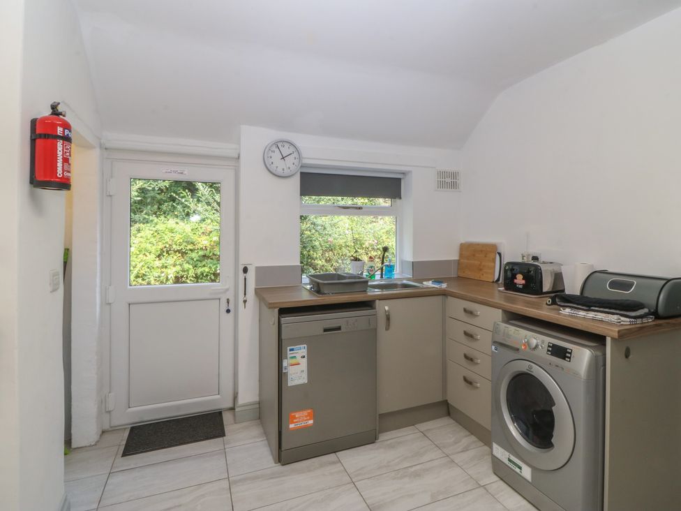 A kitchen with appliances and a door at Seaview Hafod Y Graig in Morfa Bychan