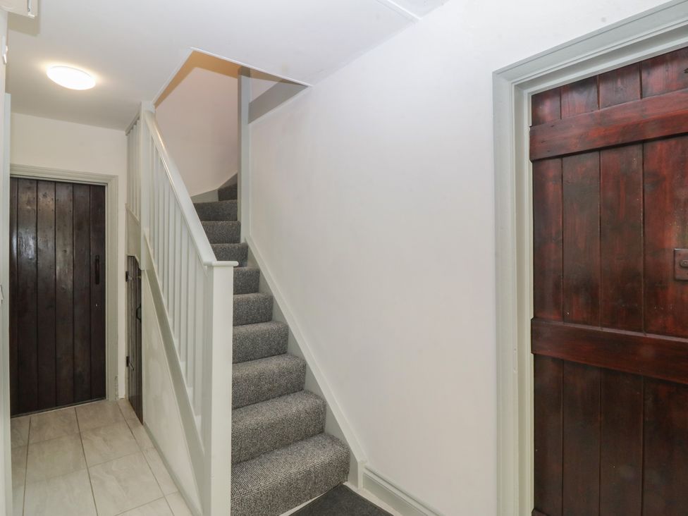 A staircase and door in a hallway at Seaview Hafod Y Graig in Morfa Bychan