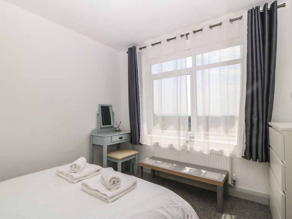 A bedroom with a bed and a mirror at Seaview Hafod Y Graig Morfa Bychan