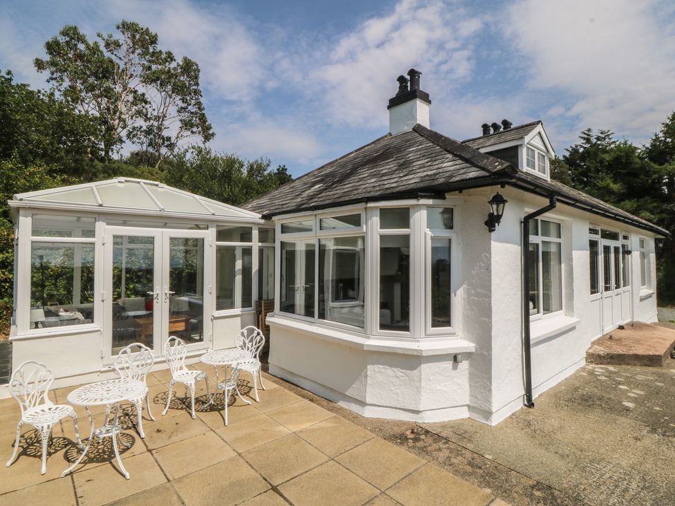 An outdoor seating area with a table and chairs at Seaview Hafod Y Graig Morfa Bychan