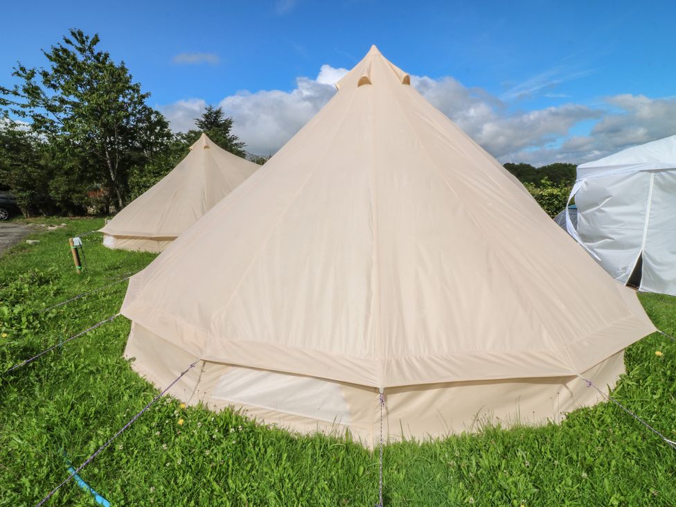 A bell tent in a grassy area with trees at Bell Tent Two