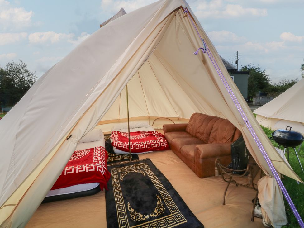 A tent with beds and a sofa at Bell Tent Two