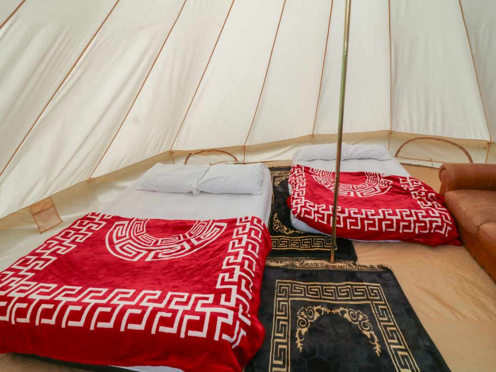 A bedroom with beds and blankets at Bell Tent Two