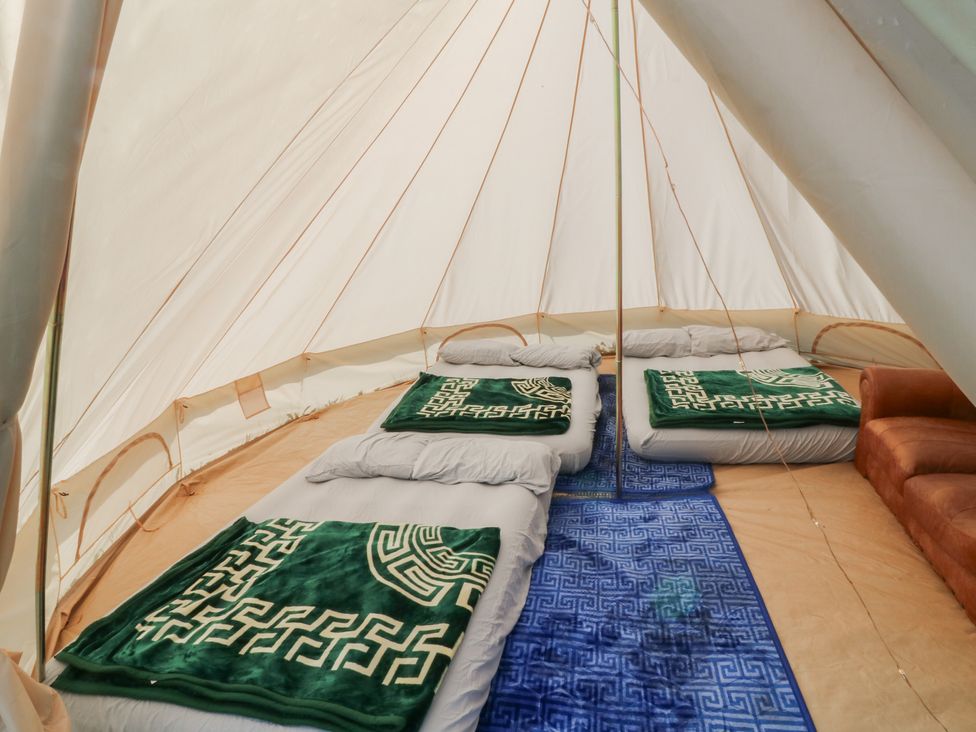 A tent with mattresses and blankets at Bell Tent Three 