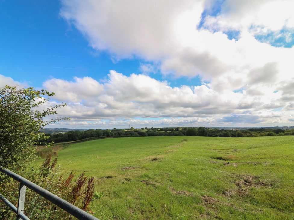 A field with grass and a fence under a cloudy sky at Bell Tent Three