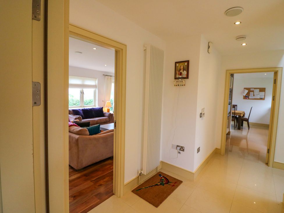 A hallway with a door leading to a living room and a dining area at 25 Ring of Kerry Holiday Cottages, Kenmare