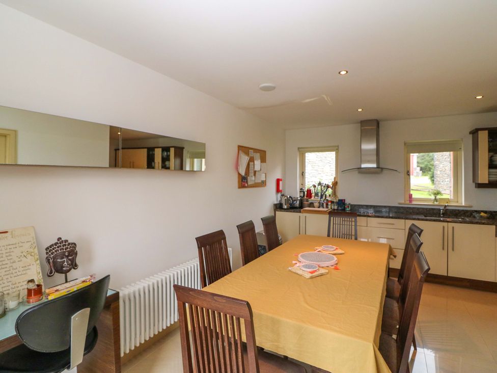 A kitchen with a dining table and chairs at 25 Ring of Kerry Holiday Cottages in Kenmare
