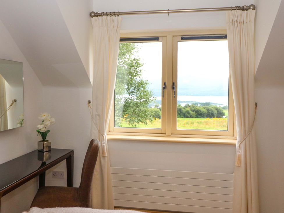 A bedroom with a window and desk at 25 Ring of Kerry Holiday Cottages in Kenmare