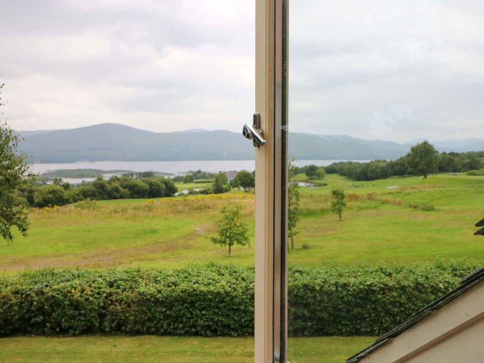 A view through a window showing a landscape with grass and mountains at 25 Ring of Kerry Holiday Cottages, Kenmare
