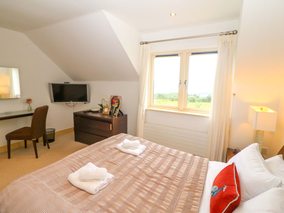 A bedroom with a bed and television at 25 Ring of Kerry Holiday Cottages in Kenmare