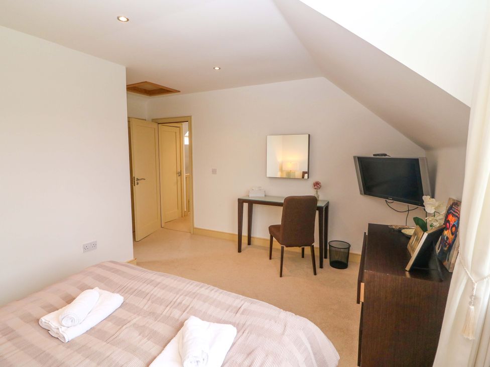 A bedroom with a bed and desk at 25 Ring of Kerry Holiday Cottages in Kenmare