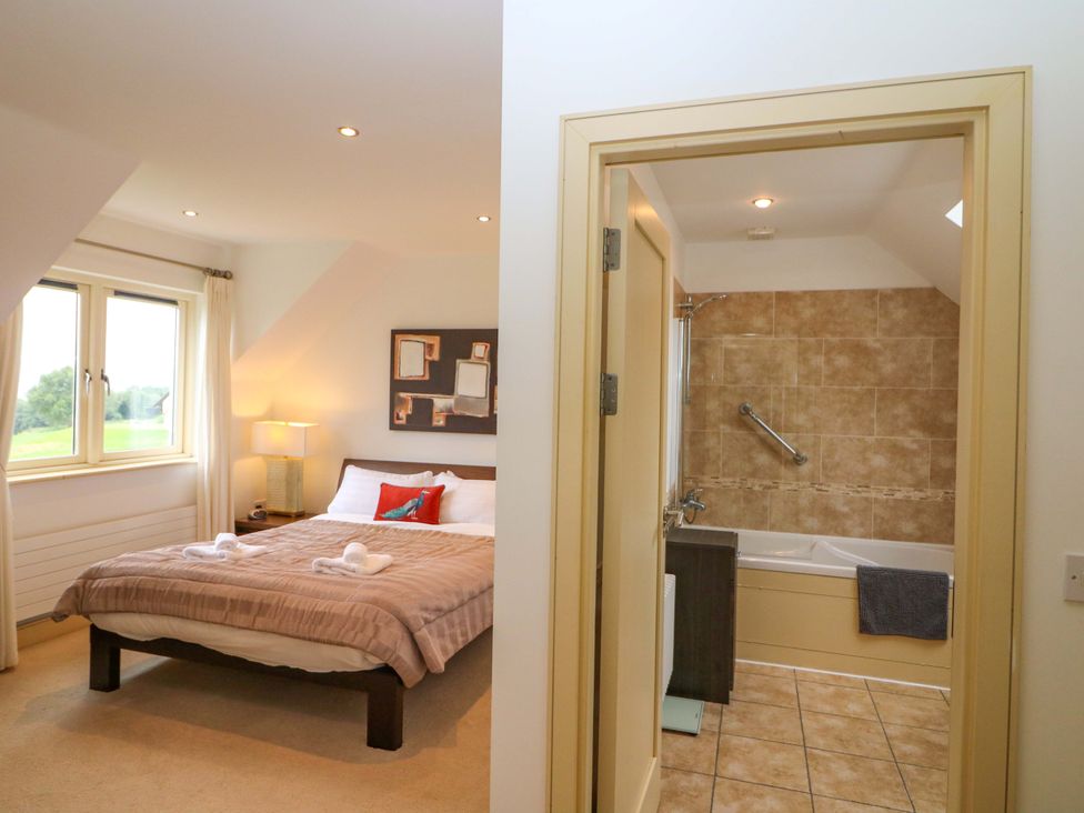 A bedroom with a bed and adjoining bathroom at 25 Ring of Kerry Holiday Cottages in Kenmare