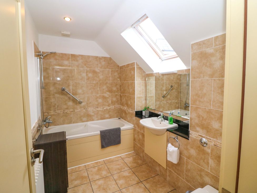 A bathroom with a bathtub and sink at 25 Ring of Kerry Holiday Cottages Kenmare