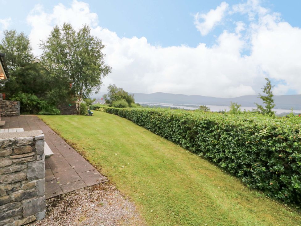 A garden with grass and a hedge at 25 Ring of Kerry Holiday Cottages in Kenmare