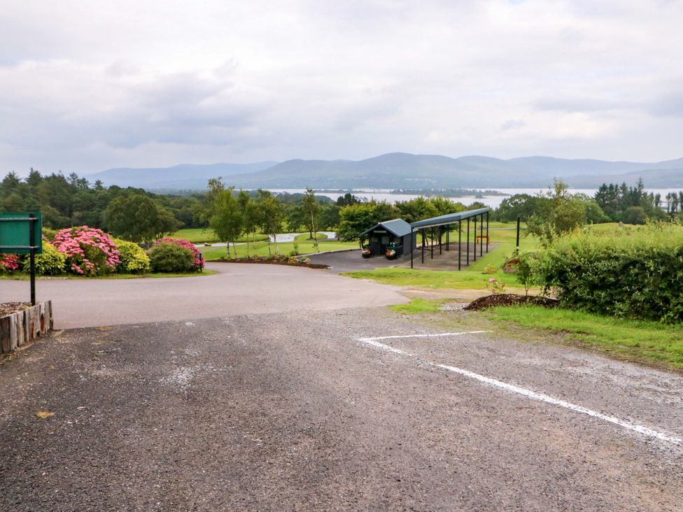 A scenic view with flowers on the side and mountains in the background at 25 Ring of Kerry Holiday Cottages