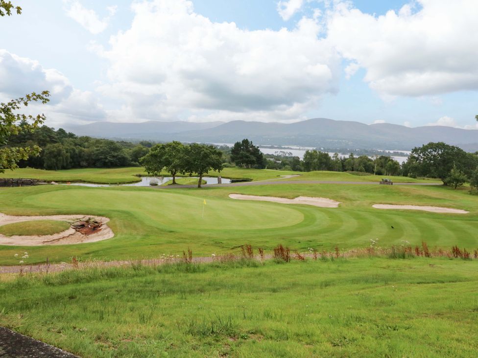 A golf course with sand traps and a water body at 25 Ring of Kerry Holiday Cottages