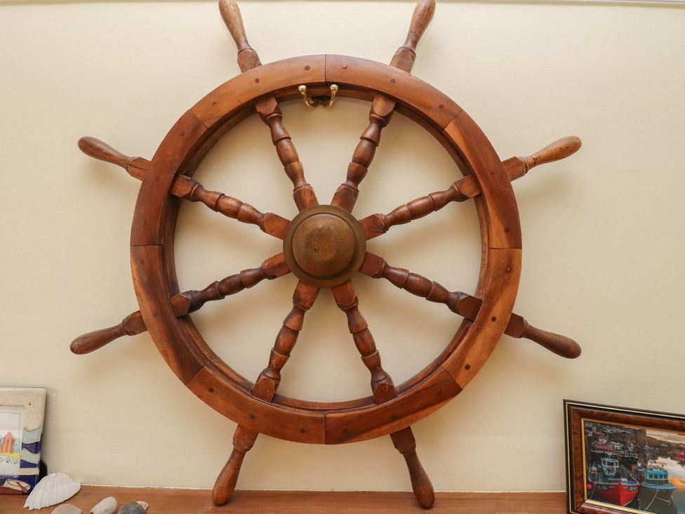 A ship's wheel on a wall at Glen Avon in Seahouses