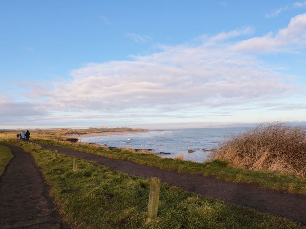 A coastal path with people walking along the sea at Glen Avon Seahouses