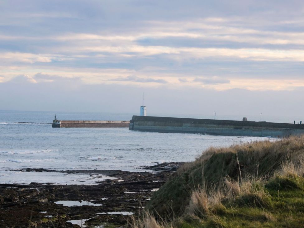 A view of a pier and lighthouse at Glen Avon in Seahouses