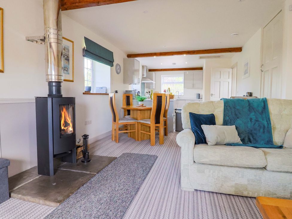 A living room with a wood stove and dining area at The Cottage Middle Westwater Westwater Nr Axminster