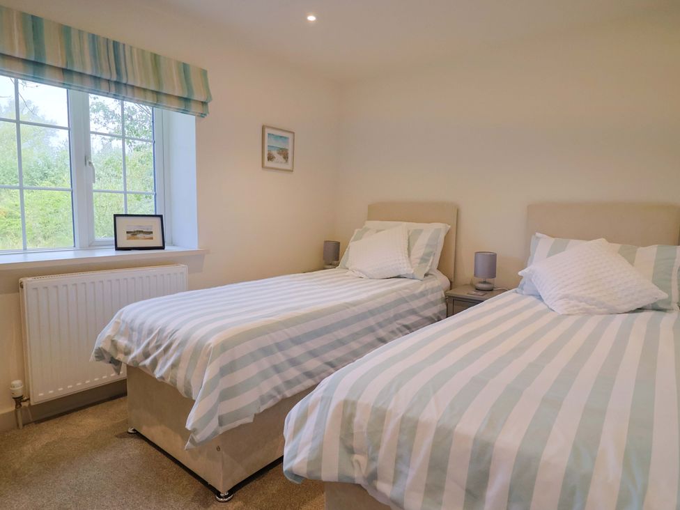 A bedroom with two beds and a window at The Cottage Middle Westwater Westwater Nr Axminster
