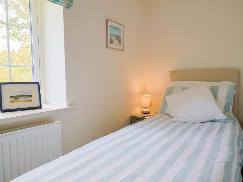A bedroom with a bed, lamp, and paintings at The Cottage Middle Westwater in Westwater Nr Axminster