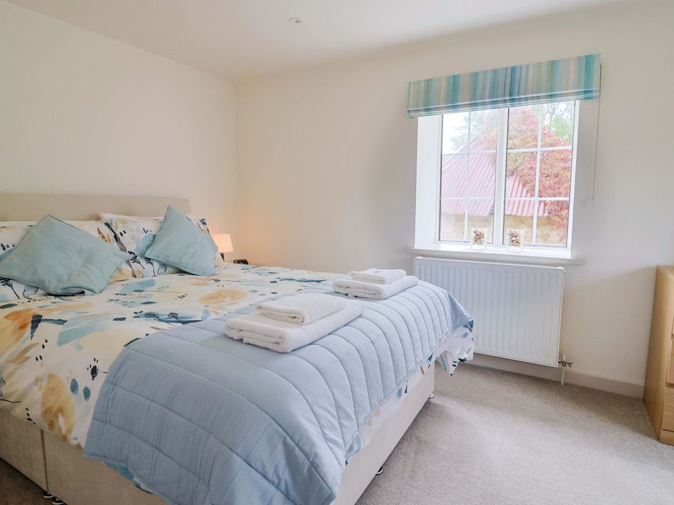A bedroom with a bed and window at The Cottage Middle Westwater