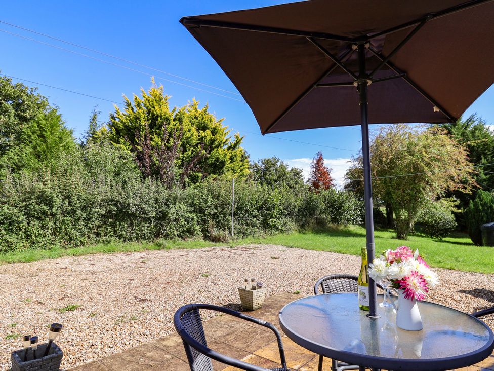 A garden with a table and chairs under an umbrella at The Cottage Middle Westwater Westwater Nr Axminster