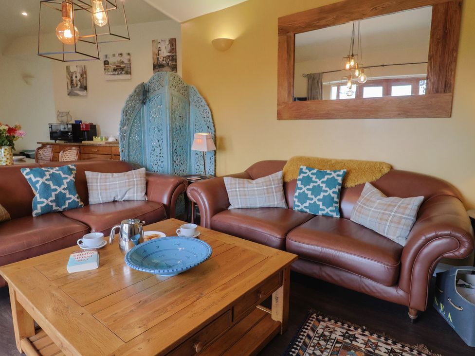 A living room with brown sofas and a coffee table at The Sundowner in Wyke Nr. Axminster